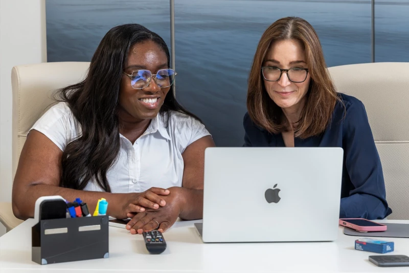Women in healthcare setting looking at laptop screen