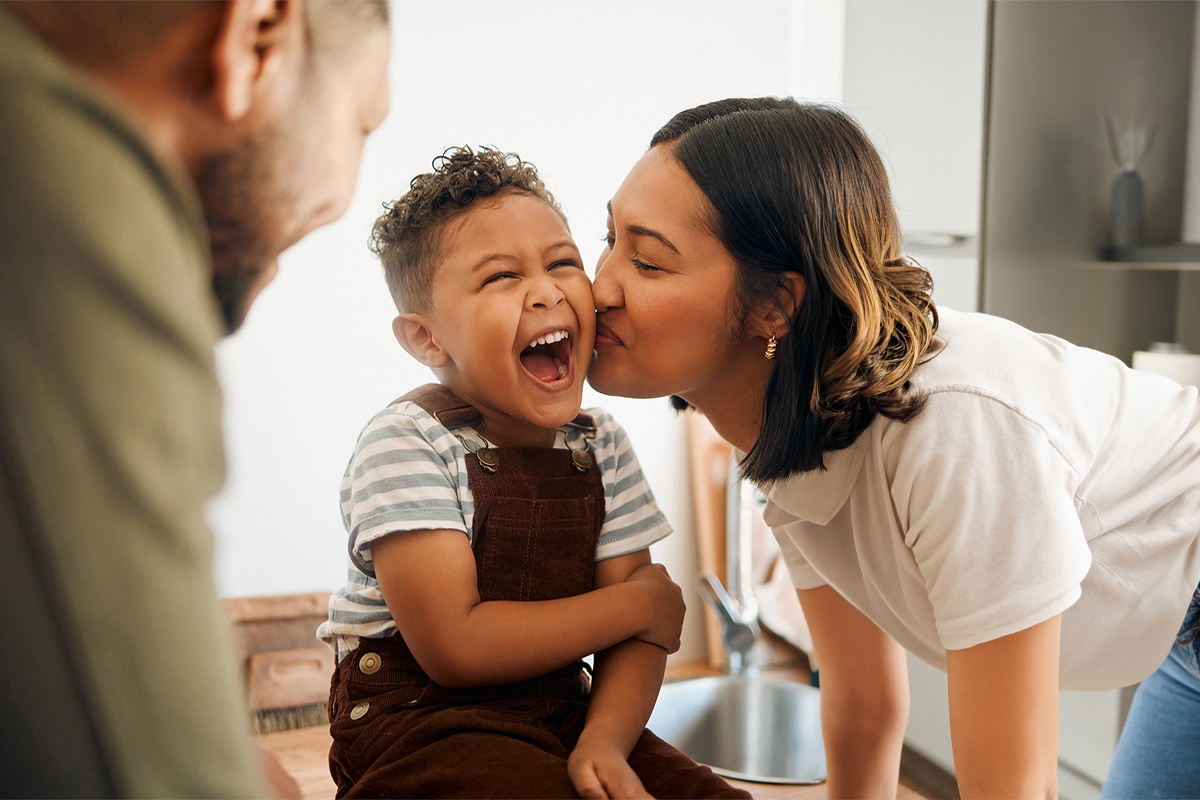 Mom kissing her child on cheek